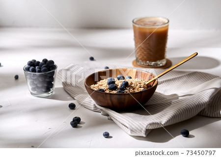 oatmeal with blueberries, spoon and coffee oatmeal with blueberries, spoon and coffee 73450797