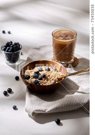 oatmeal with blueberries, spoon and coffee 73450838