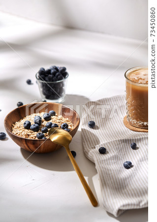 oatmeal with blueberries, spoon and coffee 73450860