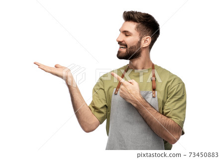 happy barman in apron holding something imaginary 73450883