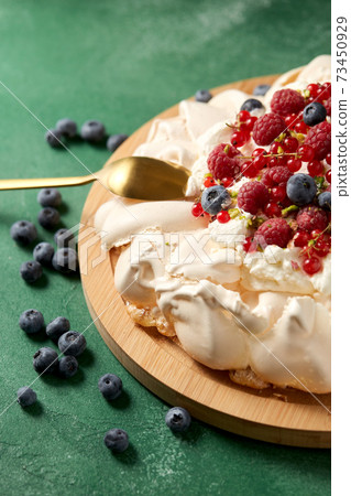 pavlova meringue cake with berries on wooden board pavlova meringue cake with berries on wooden board 73450929