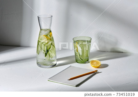 water with lemon and cucumber and notebook 73451019