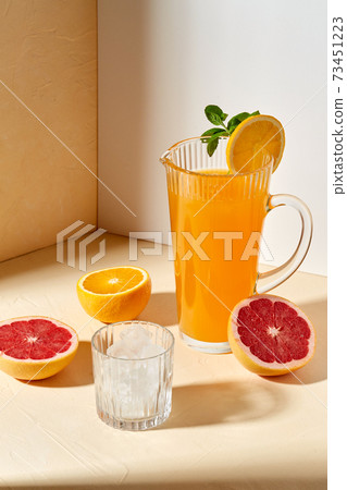 orange juice, grapefruit and ice in glass on table 73451223