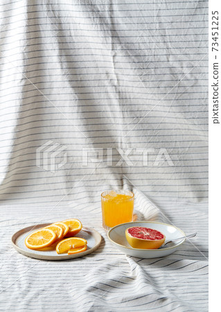 grapefruit, sliced orange and glass of juice 73451225