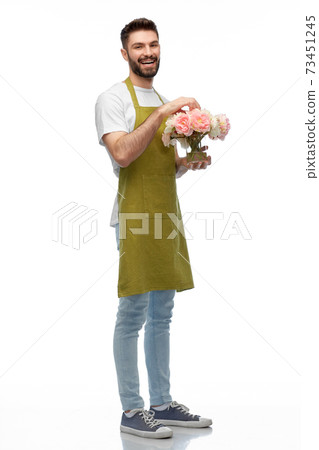 happy smiling male gardener with flowers in vase happy smiling male gardener with flowers in vase 73451245