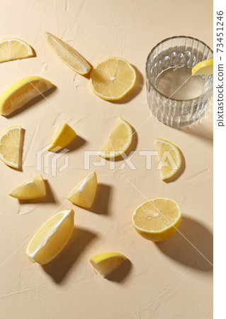 glass of water and lemon slices on table 73451246