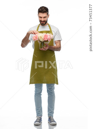 happy smiling male gardener with flowers in vase 73451377