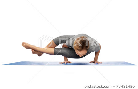 woman making yoga in handstand on mat 73451480