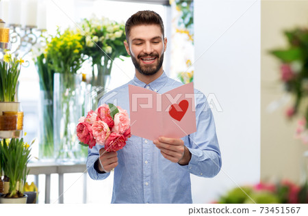 happy man with valentine's day card at flower shop happy man with valentine's day card at flower shop 73451567
