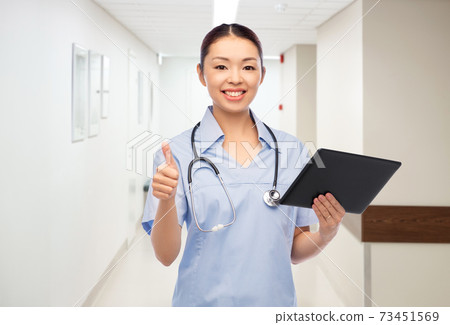 nurse with tablet pc shows thumbs up at hospital nurse with tablet pc shows thumbs up at hospital 73451569