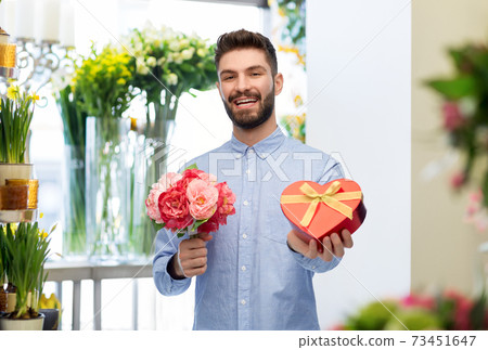 happy man with valentine's day gift at flower shop 73451647