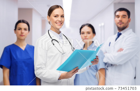 smiling female doctor with colleagues at hospital 73451703