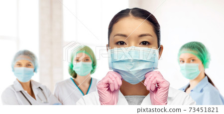 asian female doctor in medical mask and gloves 73451821