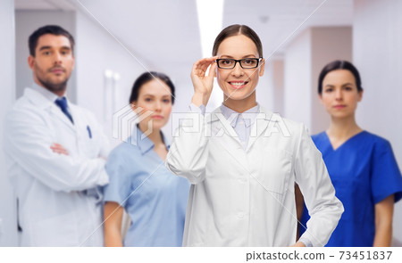 smiling female doctor with colleagues at hospital smiling female doctor with colleagues at hospital 73451837
