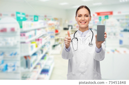 doctor with smartphone shows thumbs up at pharmacy 73451848