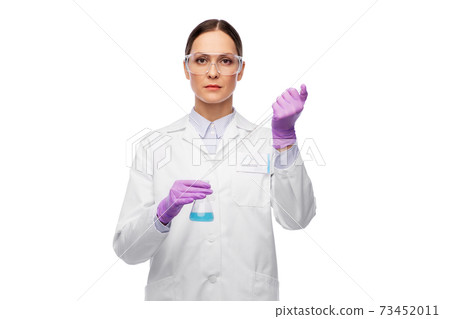 female scientist in goggles with chemical in flask female scientist in goggles with chemical in flask 73452011