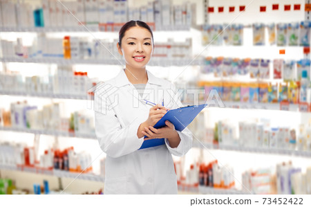 happy asian female pharmacist with clipboard happy asian female pharmacist with clipboard 73452422