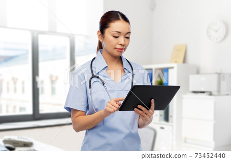 asian female nurse with tablet pc at hospital asian female nurse with tablet pc at hospital 73452440
