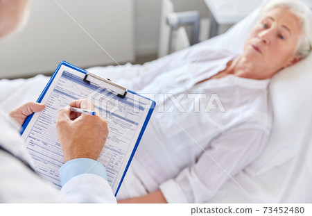 senior woman and doctor with clipboard at hospital senior woman and doctor with clipboard at hospital 73452480