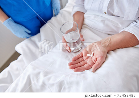 nurse giving medicine to senior woman at hospital nurse giving medicine to senior woman at hospital 73452485