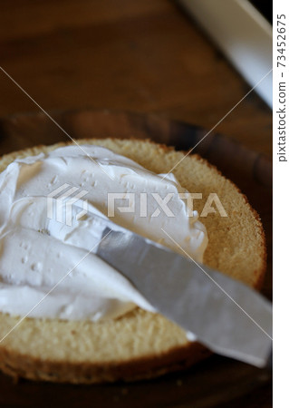 在米粉海綿蛋糕上塗抹奶油 73452675