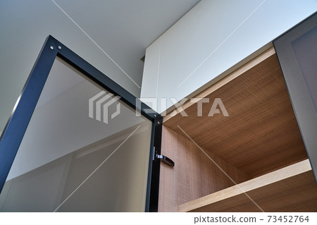 Luxury wardrobe with glass framed doors. Wooden wardrobe close-up 73452764