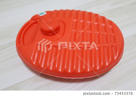 Old-fashioned orange retro hot water bottle 73453378