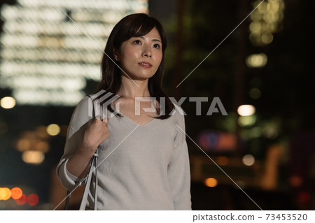 晚上走在辦公區的日本女人和從加班回來的女商人的形象 73453520