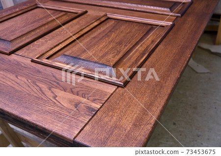 Joinery. Door leaf, painted in dark color. Wood door manufacturing process. Furniture manufacture Joinery. Door leaf, painted in dark color. Wood door manufacturing process. Furniture manufacture 73453675