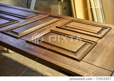 Joinery. Door leaf, painted in dark color. Wood door manufacturing process. Furniture manufacture 73453957