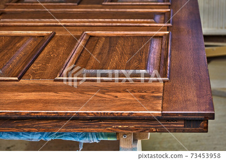 Joinery. Door leaf, painted in dark color. Wood door manufacturing process. Furniture manufacture 73453958