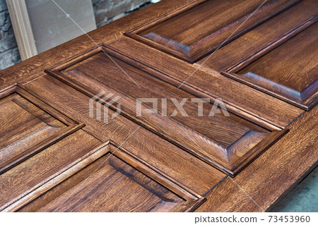 Joinery. Door leaf, painted in dark color. Wood door manufacturing process. Furniture manufacture Joinery. Door leaf, painted in dark color. Wood door manufacturing process. Furniture manufacture 73453960