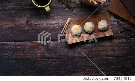 Top view of Chinese pastry or moon cake on wood dish and wood table with copy space. Top view of Chinese pastry or moon cake on wood dish and wood table with copy space. 73454012