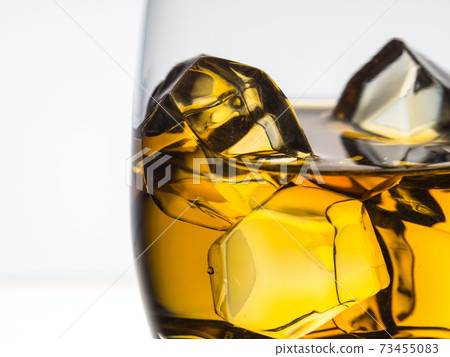 Whisky on the rocks on white background 73455083