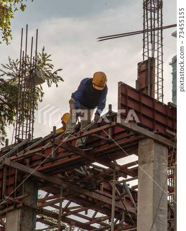 Construction Worker Welding soldering metal girders and Sparks. 73455155