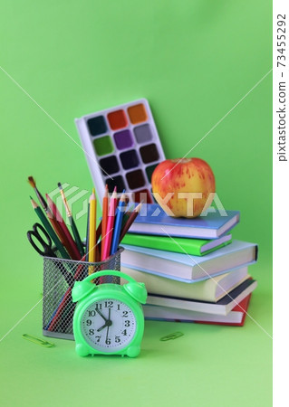 School stationery, books, alarm clock on desk, home learning concept, back to school 73455292