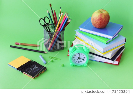 School stationery, books, alarm clock on desk, home learning concept, back to school School stationery, books, alarm clock on desk, home learning concept, back to school 73455294