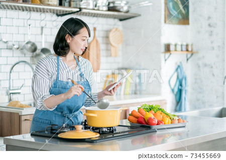 A housewife using a tablet in the kitchen 73455669