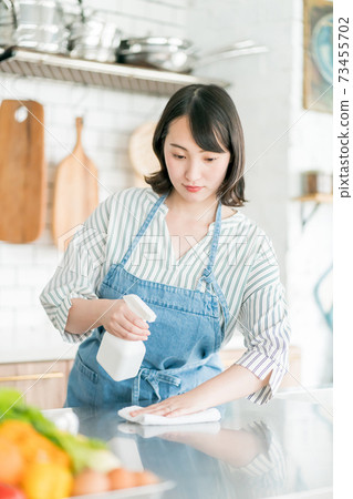 Housewife disinfecting the kitchen 73455702