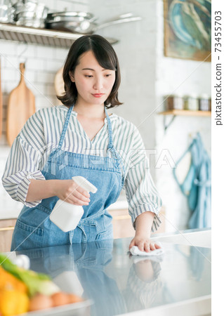 Housewife disinfecting the kitchen 73455703