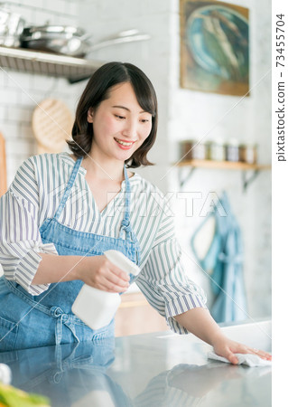 Housewife disinfecting the kitchen 73455704