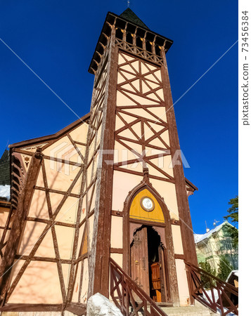 The old wooden Catholic church at ski resort, Tatranska Lomnica, Slovakia The old wooden Catholic church at ski resort, Tatranska Lomnica, Slovakia 73456384