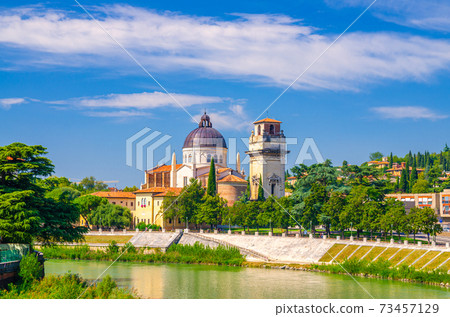 San Giorgio in Braida Roman Catholic church building with brick bell tower Campanile and dome, Adige river bank, Verona city historical centre, blue sky background, Veneto Region, Northern Italy 73457129