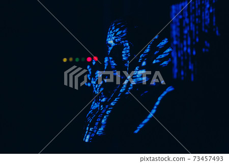 Young man with blue letters on his face in the dark. Young man with blue letters on his face in the dark. 73457493