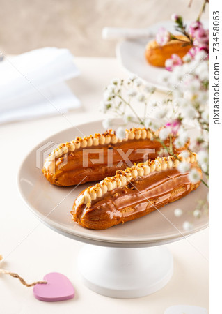 Eclairs and heart-shaped with Valentine's day decor on white background. Eclairs and heart-shaped with Valentine's day decor on white background. 73458063