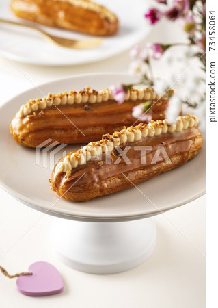Eclairs and heart-shaped with Valentine's day decor on white background. Eclairs and heart-shaped with Valentine's day decor on white background. 73458064