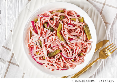 German sausage salad on a white plate, top view German sausage salad on a white plate, top view 73458349