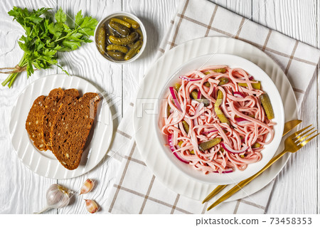 German sausage salad on a white plate, top view German sausage salad on a white plate, top view 73458353