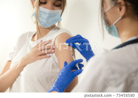 Close up doctor or nurse giving vaccine to patient using the syringe injected in hospital 73458580