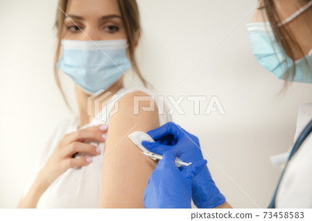 Close up doctor or nurse giving vaccine to patient using the syringe injected in hospital Close up doctor or nurse giving vaccine to patient using the syringe injected in hospital 73458583